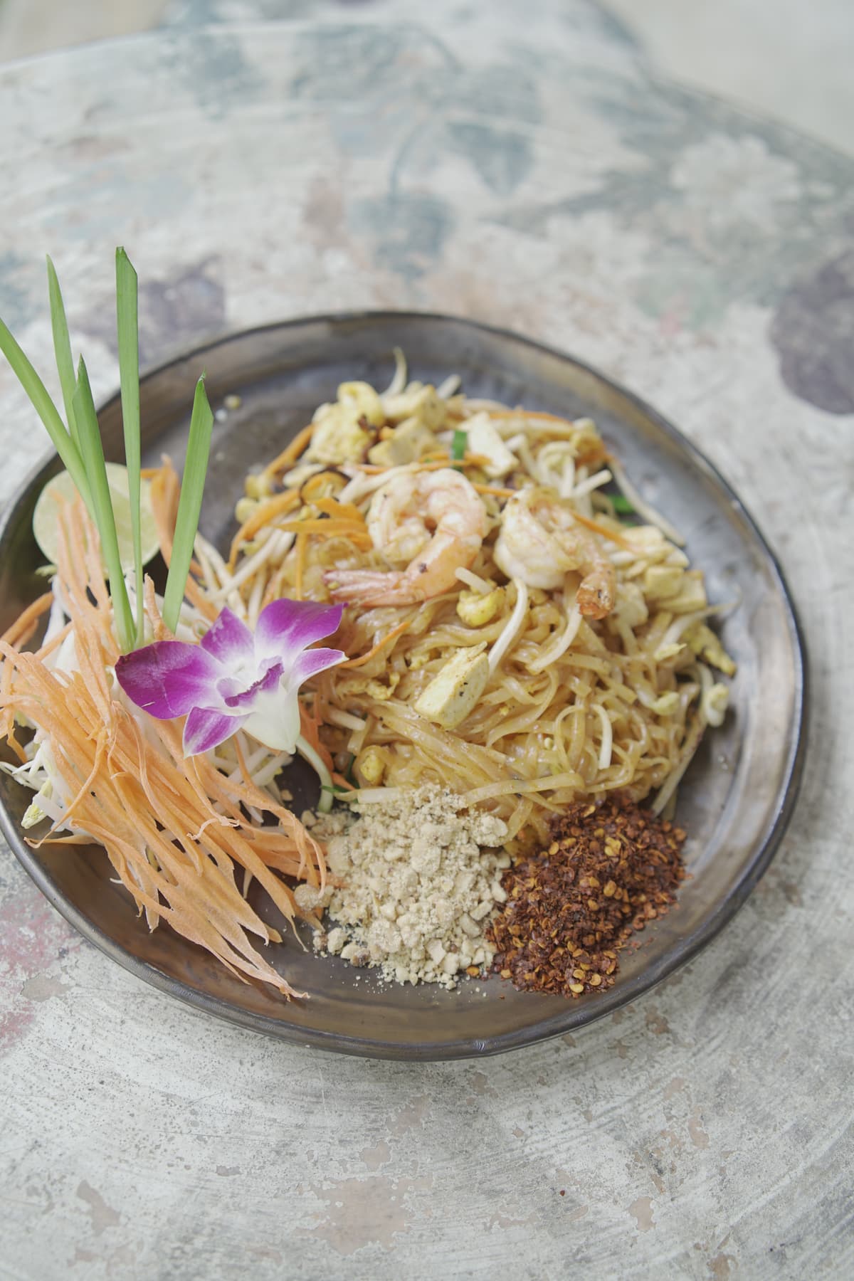 Pad thai garnished with fresh lime, peanuts and coriander