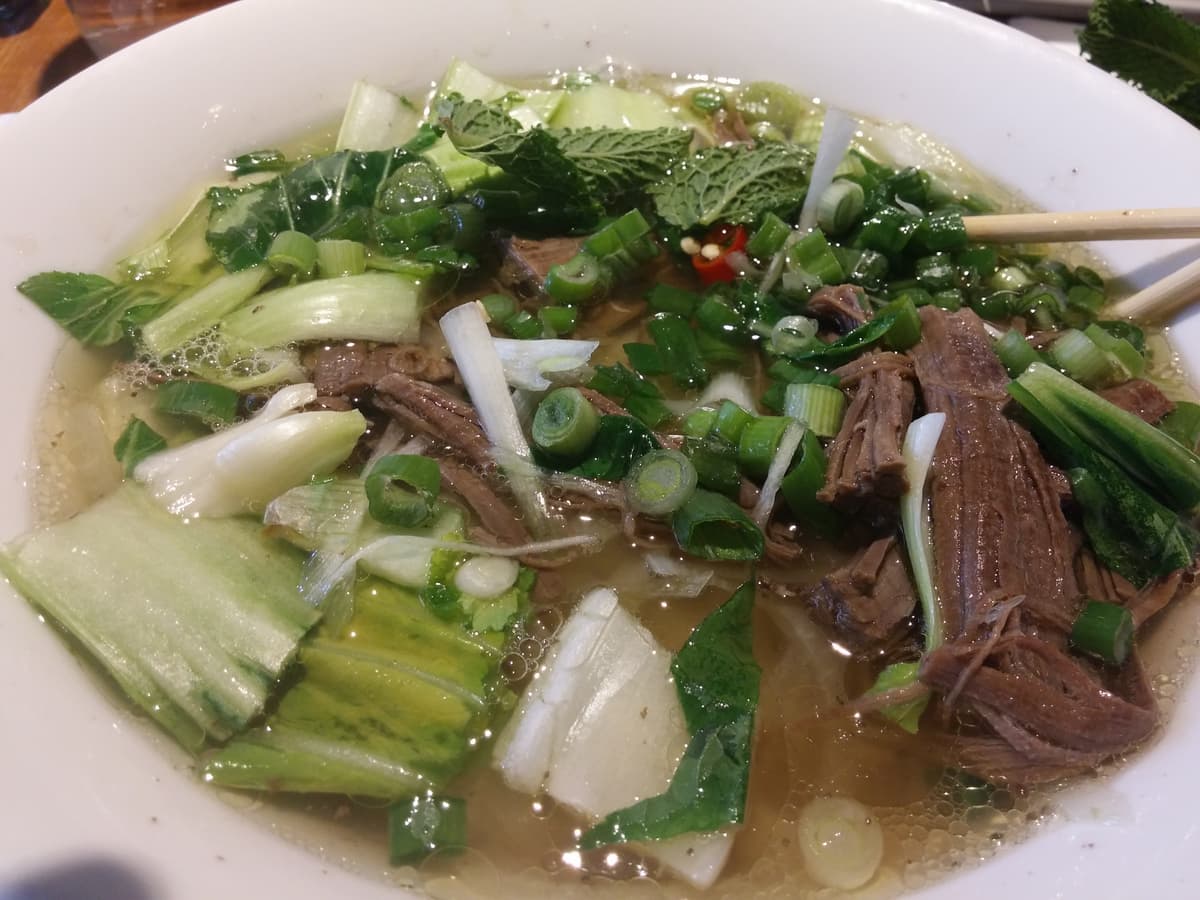 A steaming bowl of Vietnamese pho noodle soup