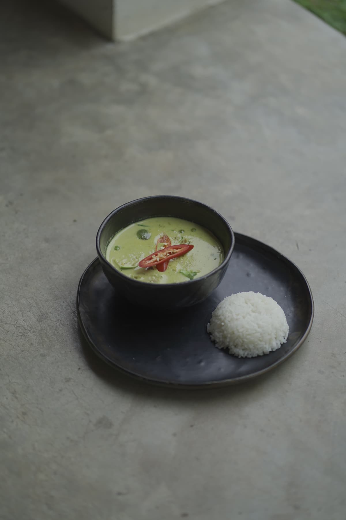 A bowl of Thai green curry served with jasmine rice